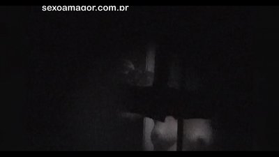 Blondina este filmată în secret de un voyeur din cartier ascuns în spatele unor cărămizi goale